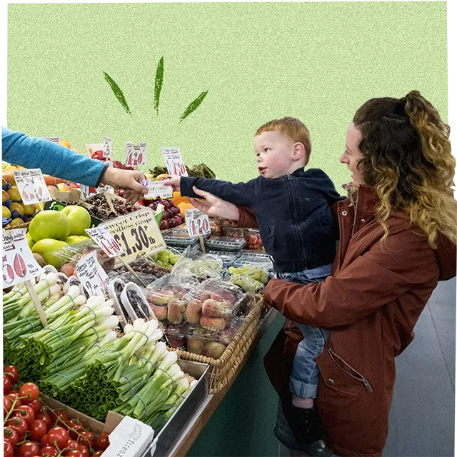 kleiner Junge kauft Obst und Gemüse mit seiner Mutter
